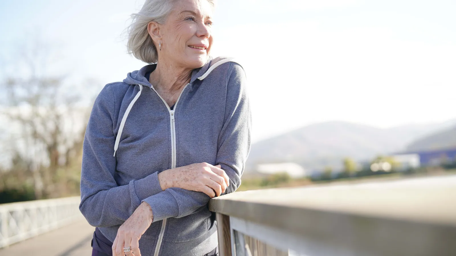 A woman standing on a hill looking at the view, a visual metaphor for the calming effect of slow diaphragmatic breathing on the nervous system.