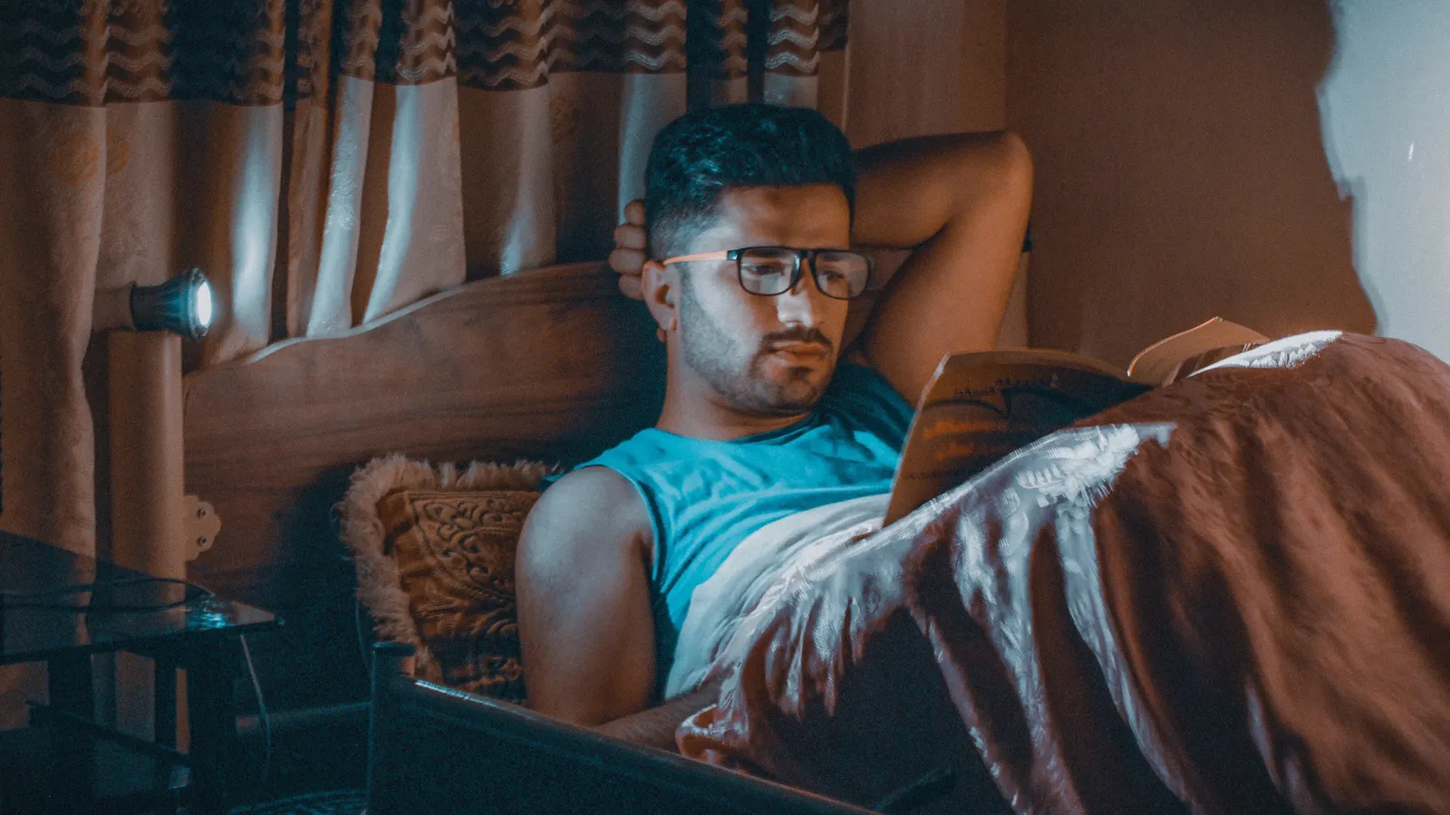 A person sleeping peacefully in dim light, suggesting the conditions that support restorative sleep.